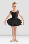 Young dancer wearing a black tutu leotard with mesh cap sleeves and attached tutu skirt, front view