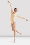 Adult dancer wearing nude long-sleeve leotard, side extension pose
