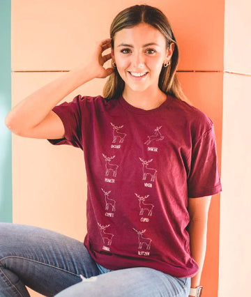 Child wearing burgundy Covet Dance leaping reindeer holiday t-shirt