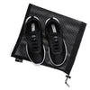 Pair of black studio trainer sneakers inside branded shoe bag
