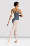 Back view of young dancer wearing a black camisole leotard walking in ballet shoes and tights