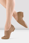 Child dancer wearing tan slip-on split-sole jazz shoes, side view