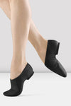 Black slip-on leather jazz shoes shown on a dancer’s feet.