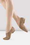 Tan slip-on leather jazz shoes shown on a dancer’s feet.