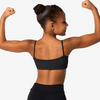 Back view of a young dancer wearing a black cropped dance top, showing a simple, supportive back design.
