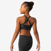 Back view of a young dancer wearing a black tank-style dance top with criss-cross straps.