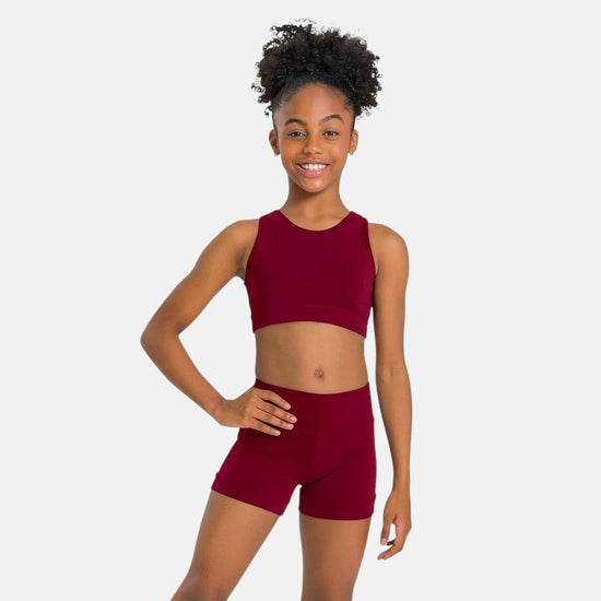 Young dancer modeling burgundy dance top and matching shorts from the front