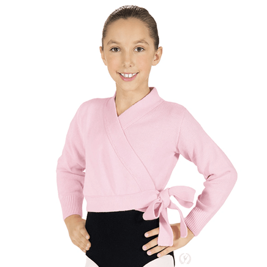 Young dancer wearing a pink long sleeve wrap ballet sweater tied at the waist over dancewear