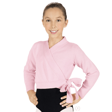 Young dancer wearing a pink long sleeve wrap ballet sweater tied at the waist over dancewear