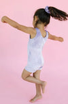 Action shot of a gymnast wearing a lilac velvet unitard during movement.