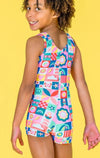 Back view of a rainbow checkerboard gymnastics unitard with multicolor graphic designs.