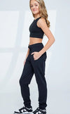 Black child jogger pants worn by a dancer shown in a side standing pose