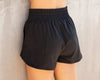 Black lightweight dance shorts with elastic waistband shown from the front