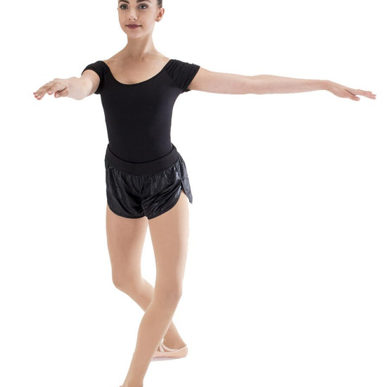 Young dancer practicing turns while standing on a SpinBoard training board.