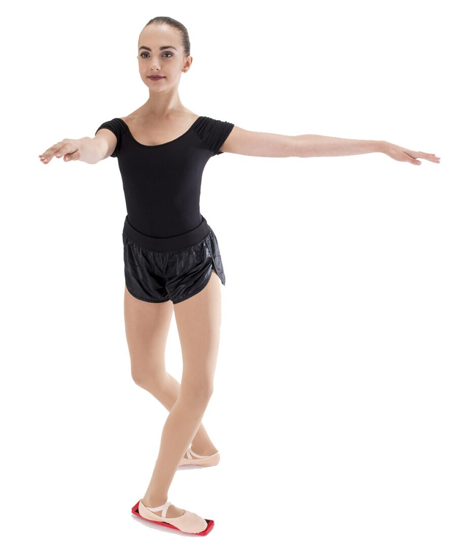 Young dancer practicing turns while standing on a SpinBoard training board.