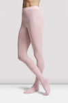 Child dancer wearing pale pink footed ballet tights standing in ballet pose