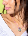 Model wearing a colorful confetti letter necklace layered on a chain.
