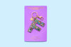 Confetti letter F acrylic keychain on a blue backer card with gold keyring