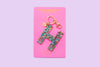 Confetti letter H acrylic keychain on a yellow backer card with gold keyring