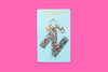 Confetti letter N acrylic keychain on a blue backer card with gold keyring