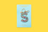 Confetti letter S acrylic keychain on a yellow backer card with gold keyring