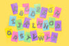 Assorted confetti letter keychains displayed together on colorful backer cards