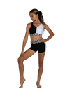 Young dancer wearing a black and white dance top and matching shorts, standing in a confident studio pose.