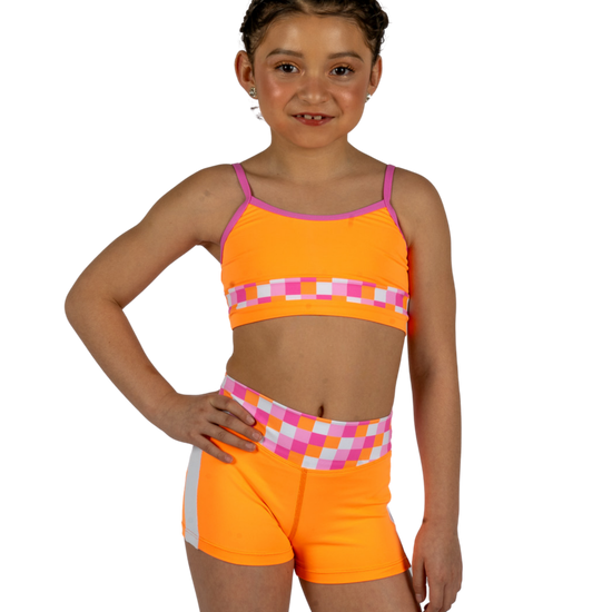 Dancer wearing an orange XO Dance Co crop top with matching shorts