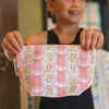 Person holding a pink pouch with ballet slipper design