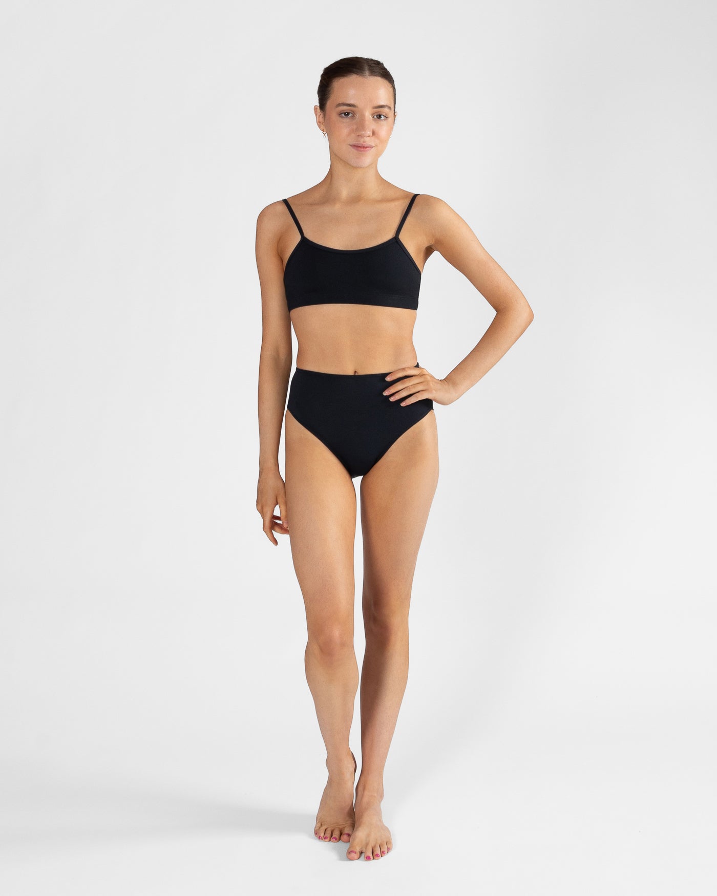 Woman wearing a black bikini set on a white background
