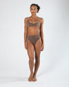 Model wearing a darker-toned high cut dance brief with matching bra, front view