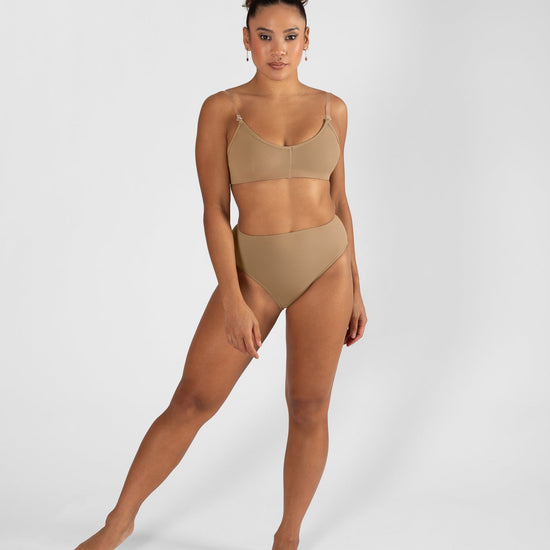 Model wearing a nude high cut dance brief with matching bra, front view