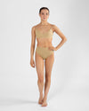 Full body front view of model wearing nude high cut dance brief and matching bra