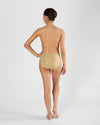 Full body back view of model wearing nude high cut dance brief and matching bra