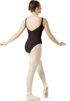 Adult dancer wearing black tank leotard in studio, side view.
