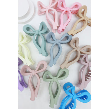 Assorted Love and Repeat matte bow hair claws in pastel pink, blue, green, purple, and neutral colors