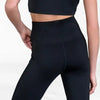 Rear view of black high-waisted dance leggings worn by a model
