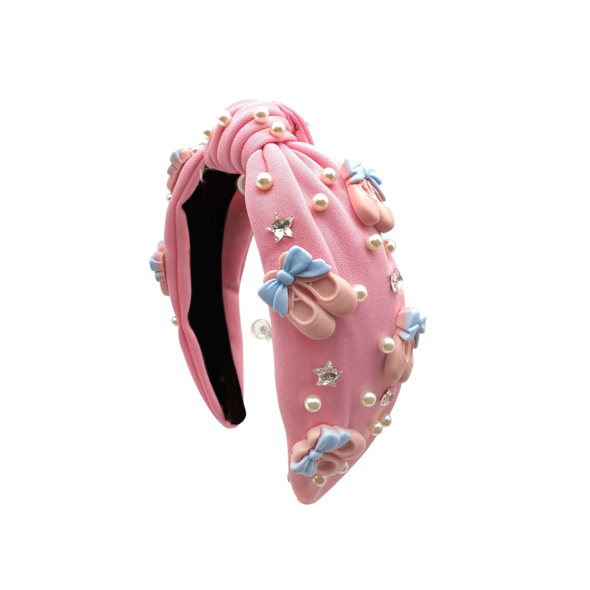 A pink headband decorated with faux pearls, small pink shoes, blue bows, and rhinestone stars, shown on a plain white background.