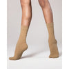 Dancer wearing tan dance socks standing with both feet visible