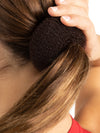Hair being wrapped around bun builder for secure bun