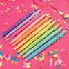 Assorted colorful pens laid out diagonally on a bright patterned background.