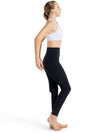 Adult dancer wearing black high-waisted leggings with a white bra top, side profile view