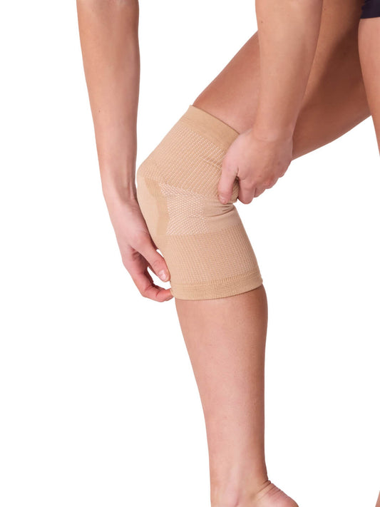 Nude gel dance kneepad worn on one knee against a white background.