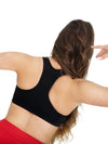 Back view of dancer wearing a black racerback bra top and red dance pants
