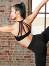 Adult dancer wearing a black strappy bra top shown from the back, highlighting the multi-strap back design