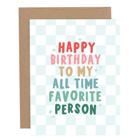 Birthday greeting card with the phrase “Happy Birthday to My All Time Favorite Person” in colorful lettering on a light blue checkered background, shown with a brown envelope.