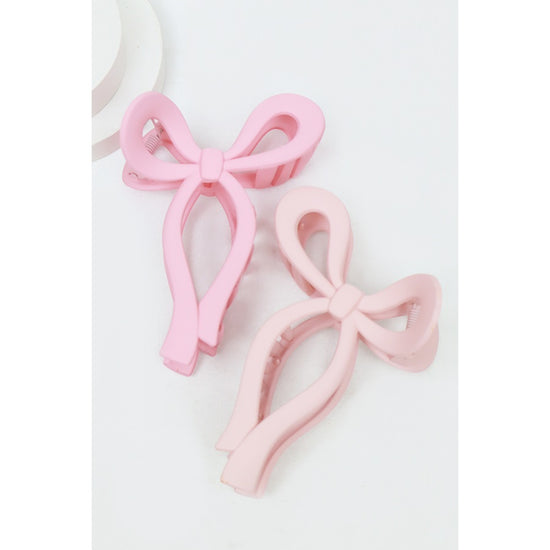 Pink Love and Repeat matte bow-shaped hair claw on a light background