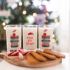 Three mini milk for Santa glasses on a table with cookies and holiday decorations