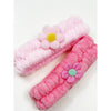 Close-up of pastel daisy spa headbands stacked together