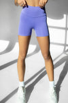 Adult dancer wearing purpledance shorts, posing indoors.